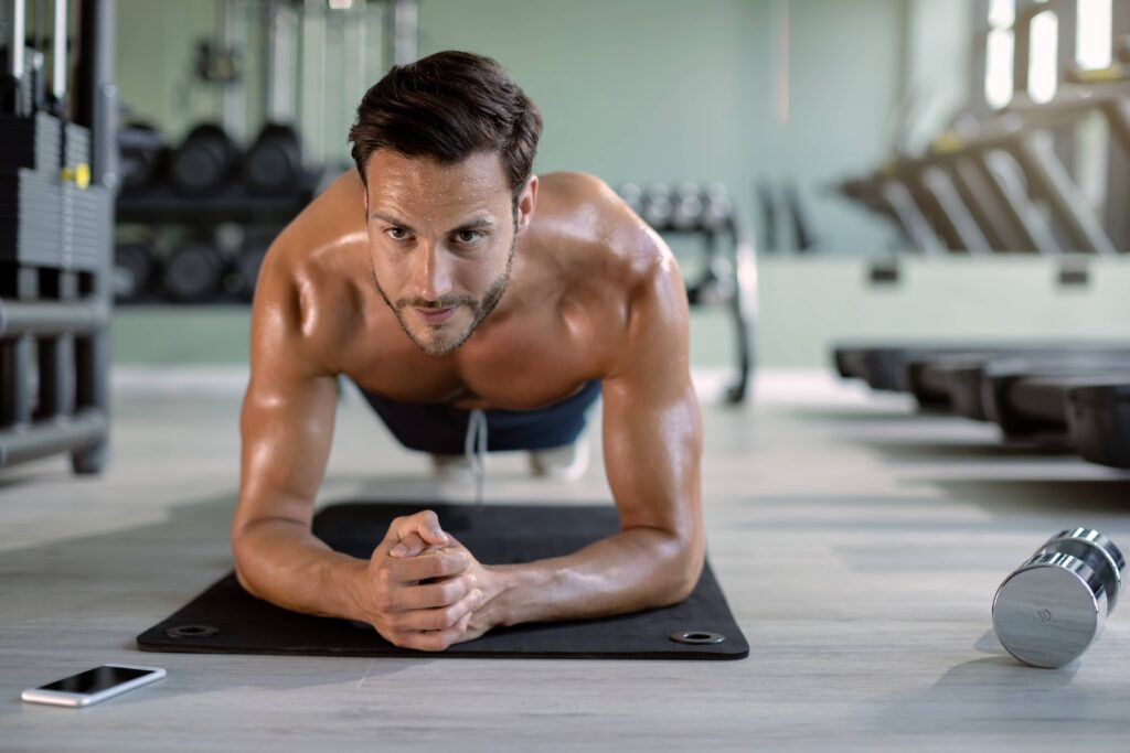 male-athlete-in-plank-pose-exercising-at-health-cl-2022-10-06-01-42-34-utc